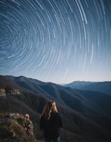 Woman Observing Star Trails Over Mountain Range photo