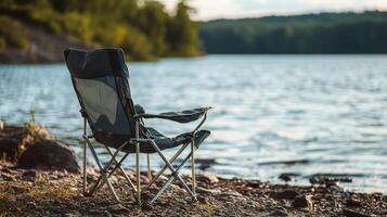 Empty folding chair by a tranquil lake shore. photo