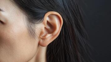 A woman with long black hair and a small ear photo