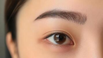 Close-up view of woman's meticulously shaped eyebrows and eye. photo