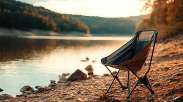 Folding chair by a tranquil lake at sunset. photo