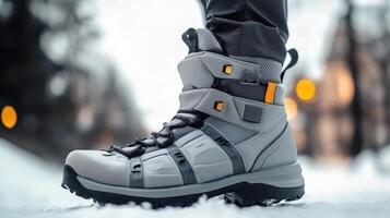 Closeup of gray hiking boots on snowy ground. photo