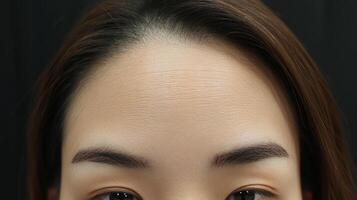 Close-up view of a person's smooth forehead and eyebrows. photo