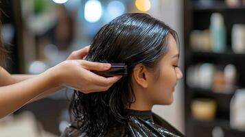 A woman's wet hair is being treated by a stylist. photo