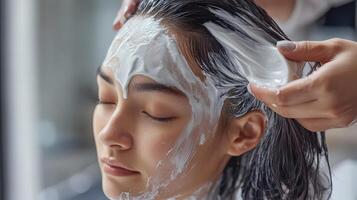 A woman getting her hair washed with a white substance photo