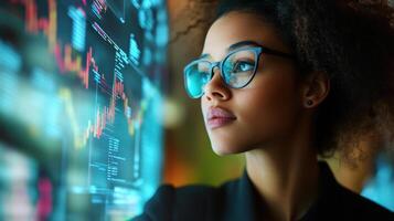 A young woman looking at digital financial charts intently photo