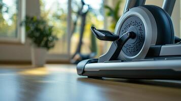 Elliptical machine detail with a blurred view of the background indoors photo