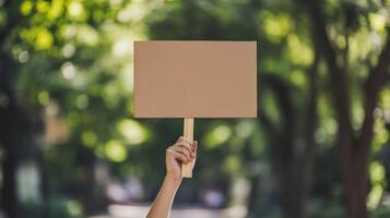 Empty protest sign held aloft in a park setting. photo