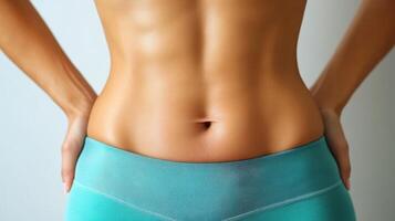 A woman's stomach with her hands on her hips photo