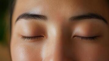 Close-up view of a person's peaceful, closed eyes and smooth skin. photo
