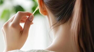 Close-up view of a person cleaning their ear with a cotton swab. photo
