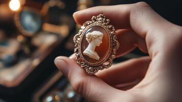 A hand holds a vintage cameo brooch. photo