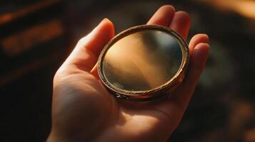 Handheld compact mirror reflecting light in warm tones. photo