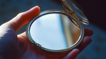 Close-up of a handheld round compact mirror. photo