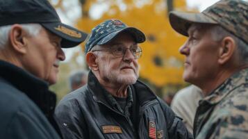 Three older veterans wearing hats engage in outdoor conversation together photo
