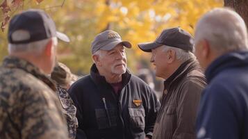 Several older men are talking to each other outdoors in the sunshine photo