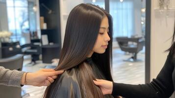 Close-up view of healthy, straight dark hair being examined in a salon. photo