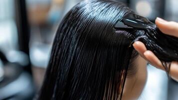 Close-up view of wet hair being treated by a stylist. photo