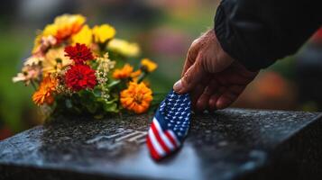 A person carefully places a small flag on a memorial stone photo