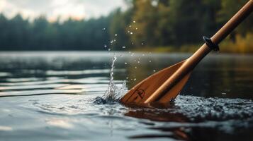 A wooden paddle creating splashes in lake water close up photo