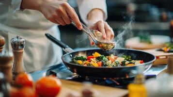 A chef cooks vegetables in a pan in a kitchen photo