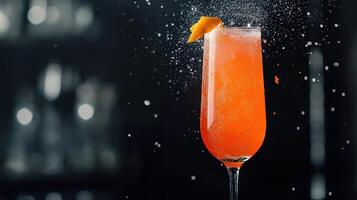 A Tall Glass Containing Orange Cocktail With Orange Peel Garnish photo