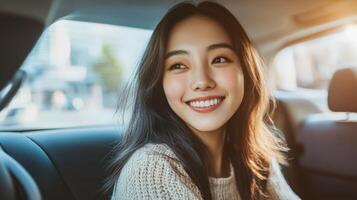 Smiling young woman inside a car's back seat. photo
