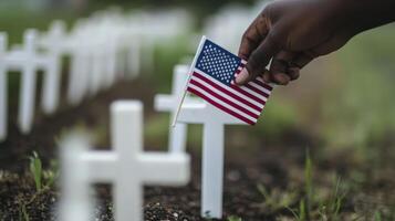 An African American hand plants a flag on a white cross photo