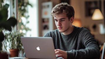 Focused young man working on a laptop computer indoors q photo