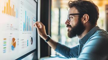 Focused man examines detailed financial charts on a large monitor. photo