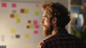 Focused young man contemplating ideas at a workspace. photo