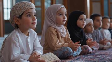 Young children in prayerful posture, seated on a rug. photo