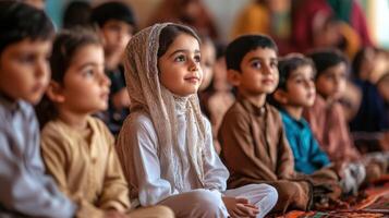 Attentive young children seated in a group, looking upwards. photo