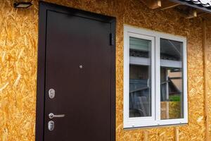 Sheathing of the house with OSB panels. The walls of the frame house are sheathed with OSB boards for further finishing. Construction of frame houses and their cladding. photo