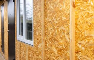The walls of the frame house are sheathed with OSB boards for further finishing. Construction of frame houses and their cladding. photo