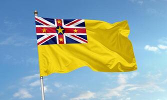 Niue flag with Union Jack and yellow field flying photo