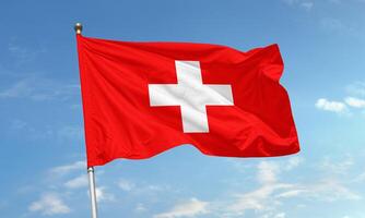 Switzerland national flag with white cross on red flying in the wind photo
