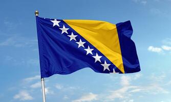 Flag of Bosnia and Herzegovina with stars and golden triangle fluttering in blue sky symbolizing peace and unity in the Balkans photo