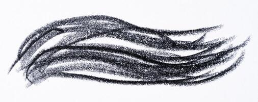 Close up of a wavy black pencil or charcoal stroke on an isolated background. photo