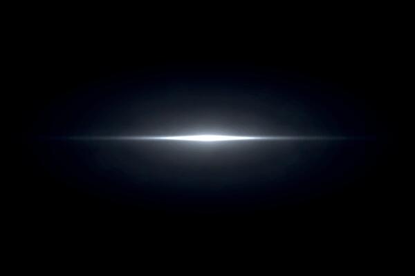 White bright light flare glowing on dark background