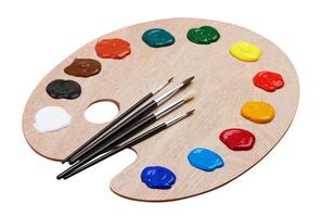 Wooden art palette with paints and brushes photo