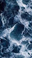 Dynamic ocean waves with white foam in deep blue sea close up. photo