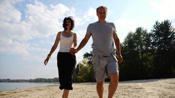 Romantic couple holding hands of each other and jogging at coastal. Happy pair running along seashore at sunny day. Lovers spending time together at resort. Concept of summer vacation or holiday photo