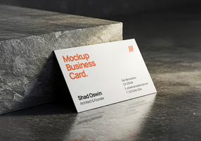 Modern business card mockup standing on textured stone surface with directional lighting and shadow play psd