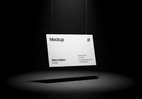 Hanging business card mockup in a dark minimal scene with dramatic spotlight and shadow beneath psd