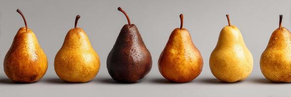 Six pears of various colors lined up on a surface. photo