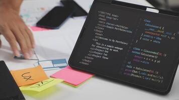 A person is working on a laptop with a programming code video