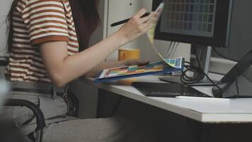 A woman is working on a computer while holding a tablet video