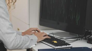 A person typing on a keyboard in front of a computer video