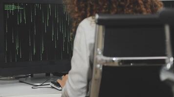 A woman is working on a computer with a green screen video